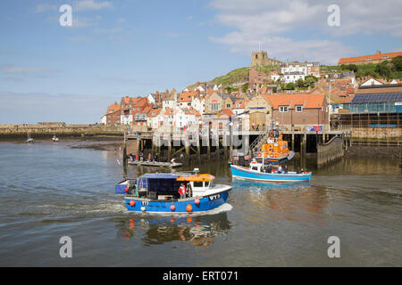 boats in Whitby Harbour with the Old Town and Church of Saint Mary, Yorkshire, England Stock Photo