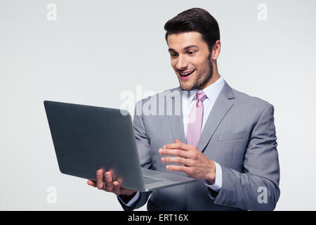 Happy businessman using laptop over gray background Stock Photo