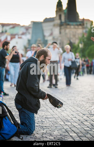 Beggar on Charles Bridge in Prague, Europe Stock Photo