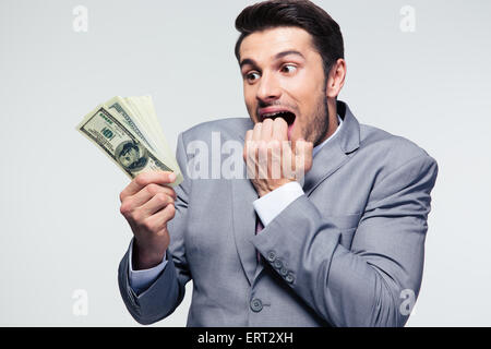 Handsome businessman holding US dollars over gray background Stock Photo