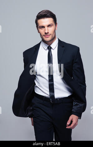 Fashion young businessman over gray background. Looking at camera Stock Photo