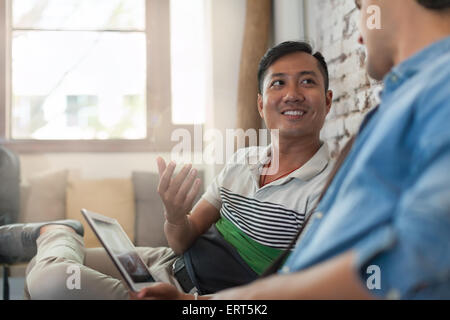 Two Men Using Laptop at Cafe, Multiethnic Friends Guys Sitting Stock Photo
