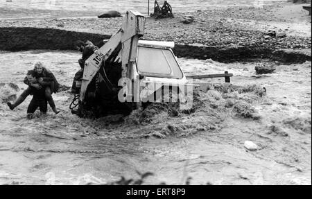 The driver of an excavator is rescued at Nolton Haven, Haverfordwest following the storms of 1987, the worst in almost 300 years.  20th October 1987. Stock Photo
