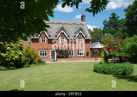 Thatched Country House with Lawned Garden Stock Photo