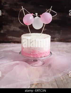Beautiful birthday / wedding cake with cream cheese frosting. Decorated with tiny balloons. Selective focus. Stock Photo