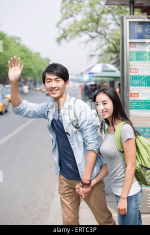 Young couple waiting at the bus stop Stock Photo