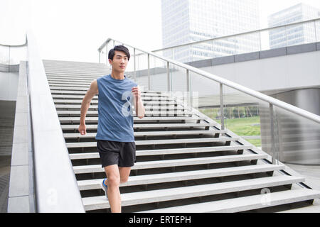 Young man running down stairs for exercise Stock Photo