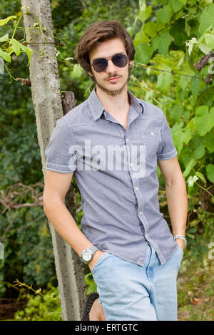 portrait of a handsome young man wearing sunglasses and enjoying the nature Stock Photo