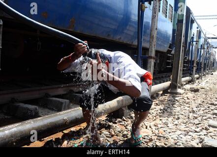 Allahabad, India. 8th June, 2015. A passenger pour water from hose pipe on his heat to being cool off during a hot day at Allahabad junction. The death toll from the blistering heat wave in India exceeded 2,500 on Sunday as weather officials said the sweltering conditions would persist for another four or five days. Pre-monsoon showers late last week in Andhra Pradesh and Telangana states in south India, where the bulk of casualties have occurred, provided some relief as daytime temperatures dropped to normal average levels. Credit:  PACIFIC PRESS/Alamy Live News Stock Photo