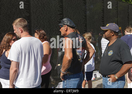 Visitors reflect while viewing names on the Vietnam Veterans Memorial in Washington, DC. Stock Photo