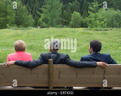 US President Barack Obama sits between Italian Prime Minister Matteo Renzi and German Chancellor Angela Merkel following an extended group photo on the second day of the G7 Summit meeting at the Schloss Elmau June 8, 2015 near Garmisch-Partenkirchen, Germany. Stock Photo