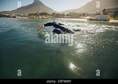 Athletes in the swim event of a triathlon competition. Triathletes swimming in open water. Stock Photo