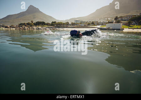 Male athlete swimming in open water. Athlete practicing for the triathlon competition. Stock Photo