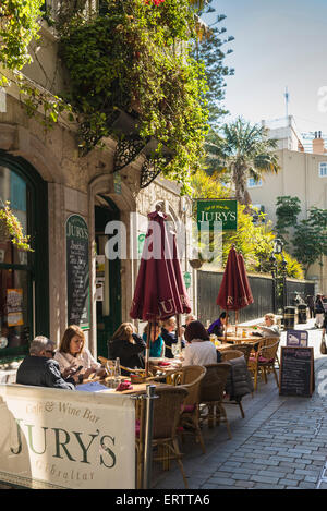 Gibraltar sidewalk pavement cafe bar in a street in Gibraltar city center, Europe with people sitting outside in summer Stock Photo