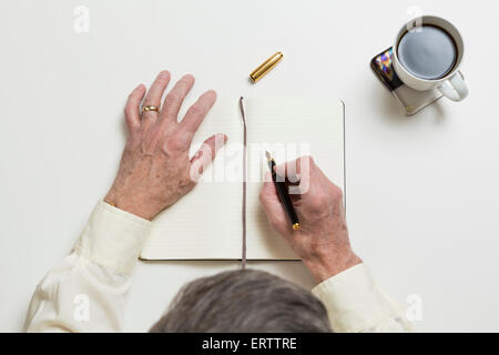 Man / businessman writing in a notebook in an office meeting or business meeting environment concept Stock Photo