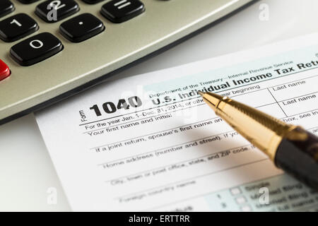 USA tax form 1040 for year 2014 with a pen and calculator illustrating completion of tax forms for the IRS Stock Photo