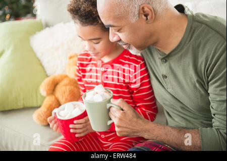 Mixed race grandfather and grandson drinking hot chocolate at Christmas Stock Photo