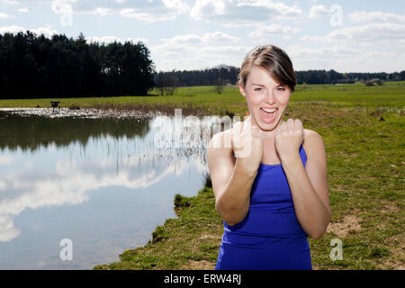 young woman standing by a lake and in boxer pose Stock Photo