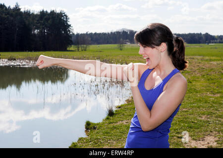 young woman standing by a lake and in boxer pose Stock Photo