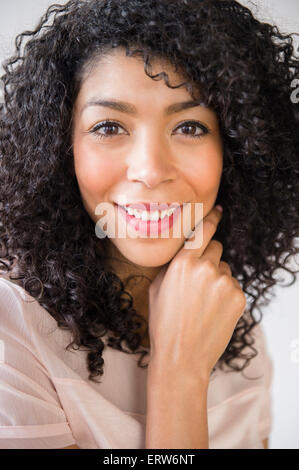 Mixed race woman with curly hair smiling Stock Photo