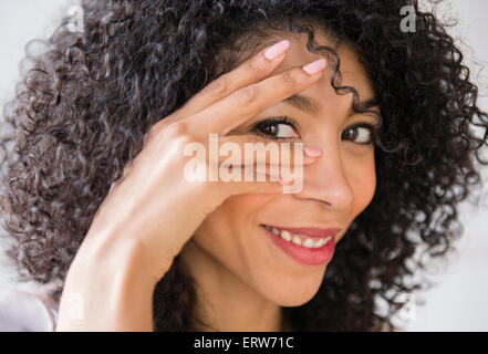 Mixed race woman with curly hair smiling Stock Photo