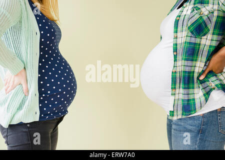 Pregnant women displaying profile of midsections Stock Photo