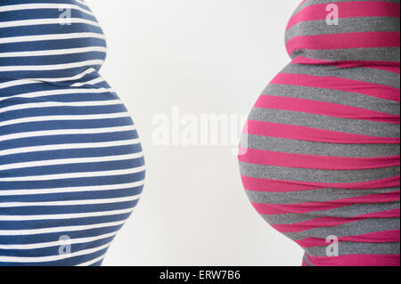 Close up midsection profiles of stomachs of pregnant women Stock Photo