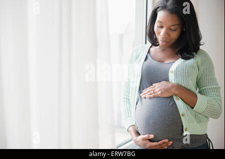 Pregnant woman wearing support underwear and holding belly - Stock Image -  C054/1961 - Science Photo Library