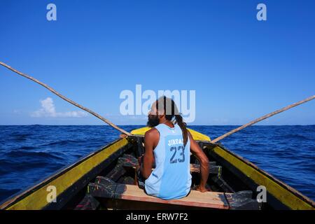 Rasta fisherman in a wooden boat in Port Antonio, Jamaica Stock Photo