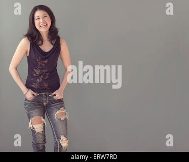 Mixed race woman wearing ripped jeans Stock Photo