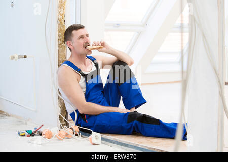 repairman having a break and eating a sandwich Stock Photo