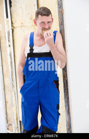 repairman having a break and eating a sandwich Stock Photo