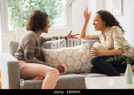 Laughing women talking on sofa Stock Photo