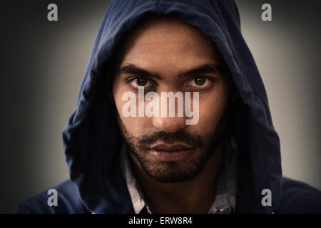 Serious Hispanic man wearing hoodie Stock Photo