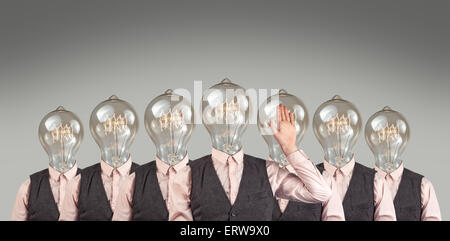 Lightbulb head businessmen in large group business meeting Stock Photo