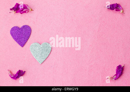 Purple and silver hearts and flower petals on pink background Stock Photo