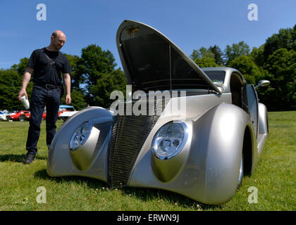 Old Westbury, New York, United States. 7th June 2015. A visitor looks at an ultra low to the ground silver 1937 Ford, the First Place winner in the Modified Car category, at the 50th Annual Spring Meet Car Show sponsored by Greater New York Region Antique Automobile Club of America. Over 1,000 antique, classic, and custom cars participated at the popular Long Island vintage car show held at historic Old Westbury Gardens. Stock Photo