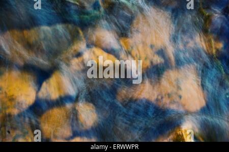 Moving water in river over rocks. Stock Photo