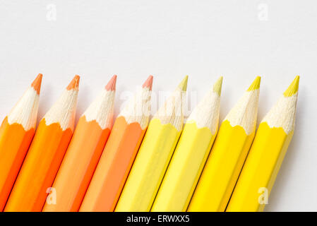 Orange and yellow coloring pencils on a white background Stock Photo