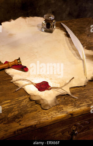 Empty parchment scroll with wax seal and feather quill Stock Photo