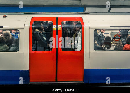 Tube train full of people on London underground - doors closed Stock Photo