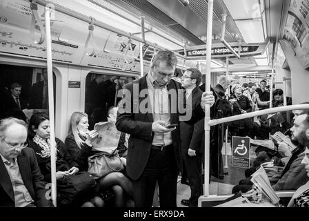 White man using his mobile phone on a London underground train. Stock Photo