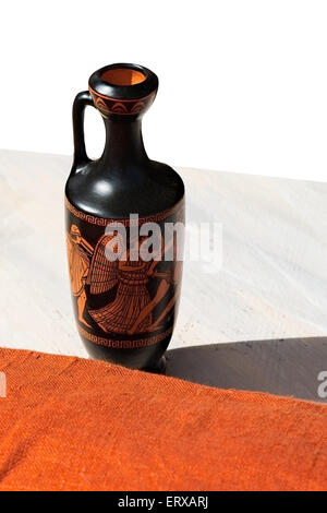 Ancient Greek  Lekythos - small container for olive oil on a table, isolated against white background. Vertical photography Stock Photo