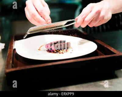 Chef Grating Spice on Deer Meat with Peanut Stock Photo