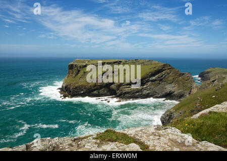 Famous cliffs at Tintagel Cornwall showing the site of the castle. Clear day with blue skies and a heavy swell in the sea. Stock Photo