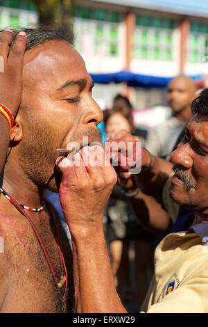 Face piercing, Preparation for the Tamil Hindu Thaipusam celebration in the Thai month when the star Pusam is at its height Stock Photo