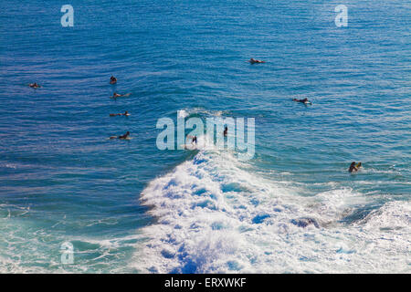 Unidentified surfers catching a wave off the northwest coast of Maui. Stock Photo