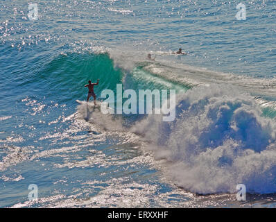 Unidentified surfers catching a wave off the northwest coast of Maui. Stock Photo