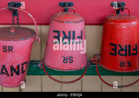 Red fire buckets at Horsted Keynes Railway Station on the Bluebell Railway Heritage Line, West Sussex, England, United Kingdom. Stock Photo