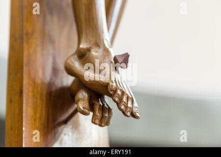 Detail of nailed feet in a wood carved statue  of the Crucifixion of Jesus Christ Stock Photo